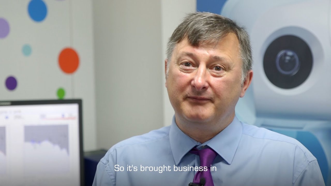 Audiologist sharing success story in a clinic setting, emphasizing business growth from hearing care services.