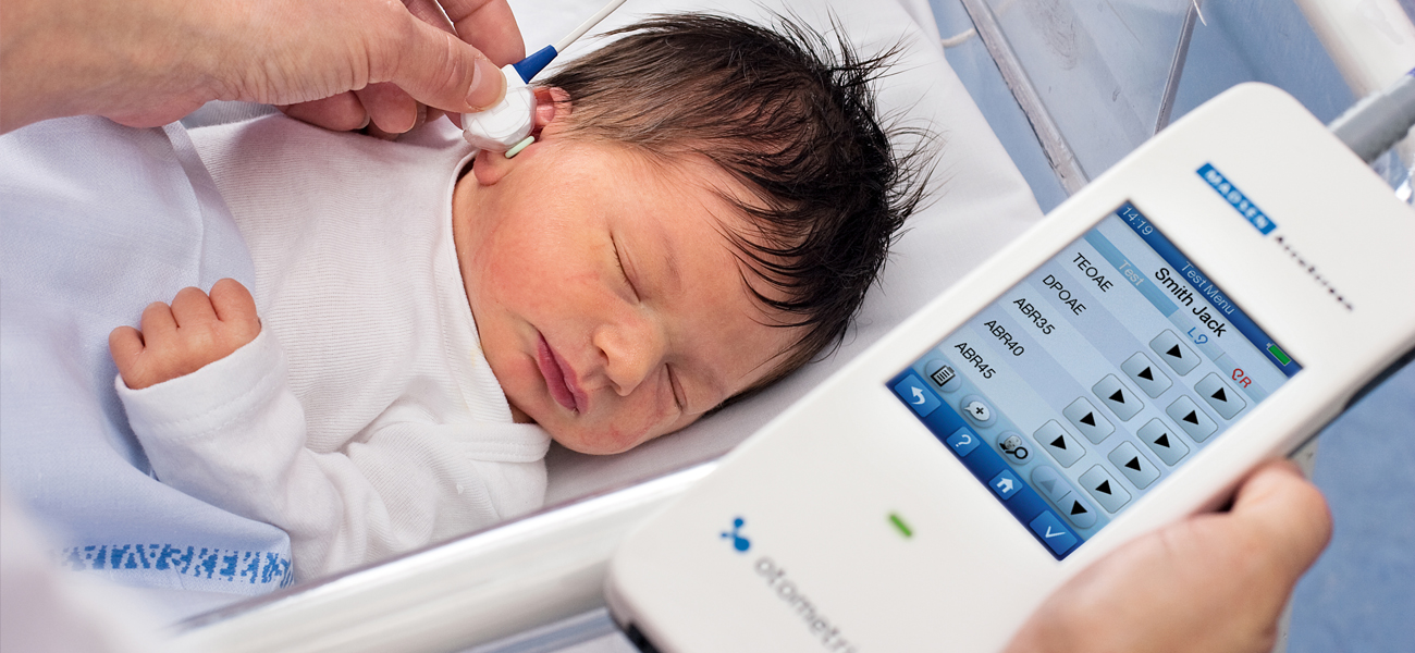 Clinician performing OAE and ABR testing on a newborn using the Madsen AccuScreen device.