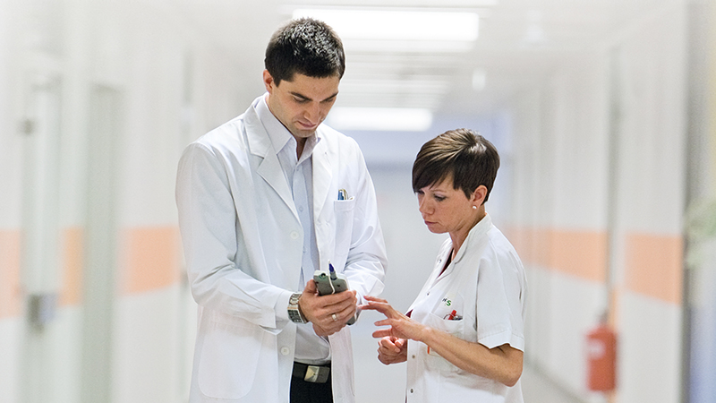 Clinicians reviewing newborn hearing screening results on the Madsen AccuScreen with OAE and ABR testing.