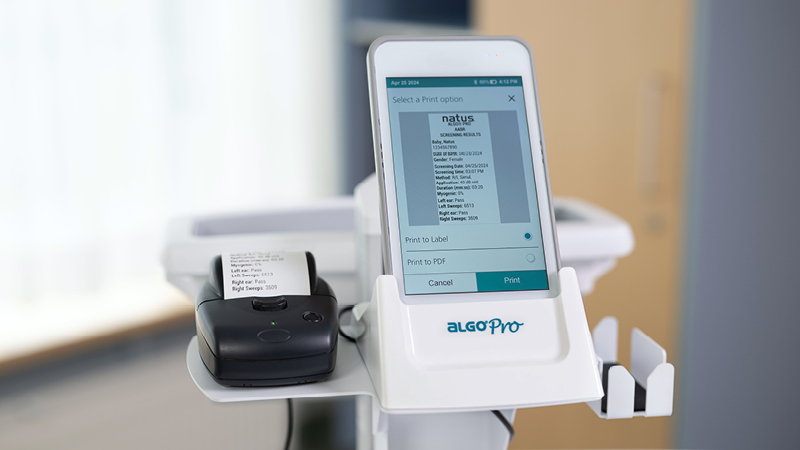Close-up of ALGO Pro Mobile Hearing Screening System displaying infant test results with integrated label printer.