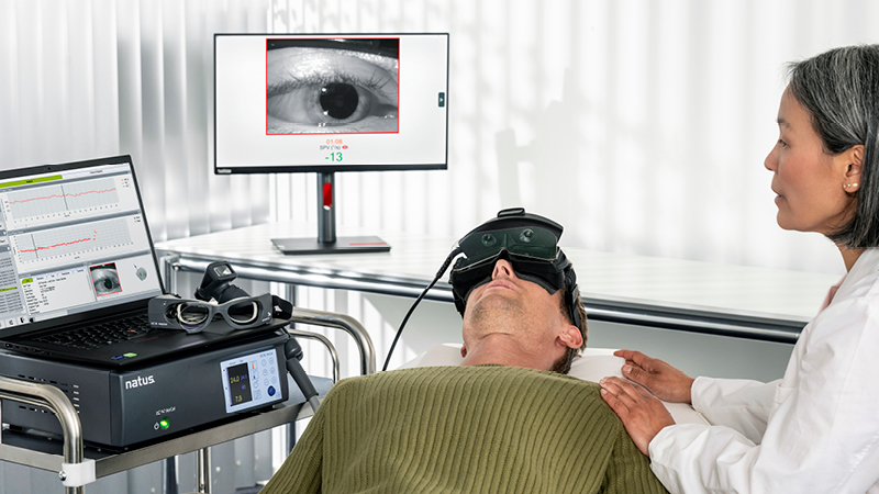 Clinician monitoring a patient undergoing vestibular testing with ICS Dizcovery VNG goggles, displaying real-time eye movement data on connected screens.