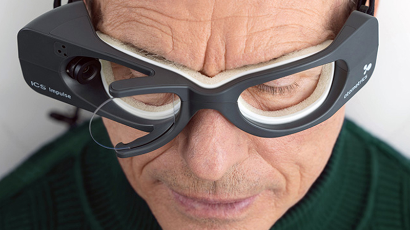 A patient wearing ICS Impulse vHIT goggles during vestibular assessment, showing camera and ergonomic design.