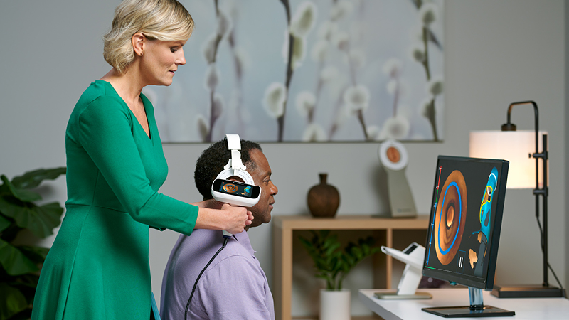 Clinician performing 3D ear scanning with Otoscan while visualizing the scan results on a computer screen.