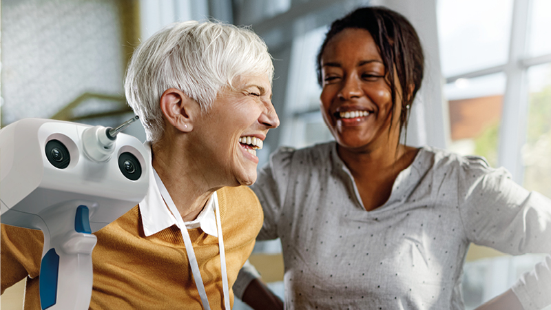 Smiling patient and clinician with a noninvasive 3D ear scanner for digital ear impressions.