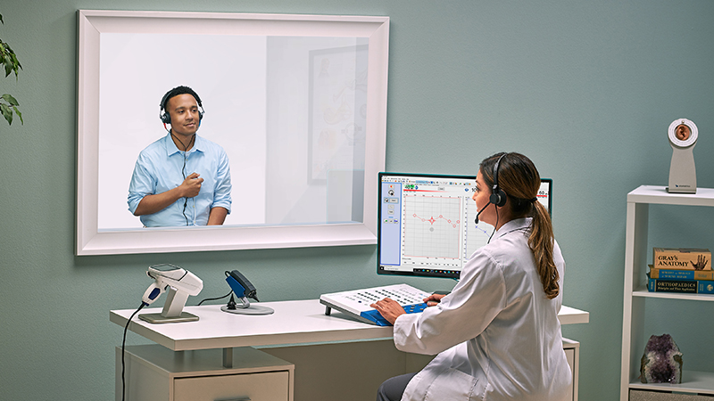 Audiologist using Madsen Astera2 clinical audiometer for PC based audiometric testing during patient hearing assessment.