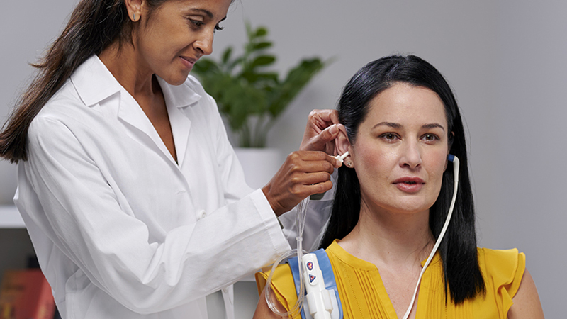 Clinician performing immittance test with Madsen Zodiac tympanometer and Gen 2 probe on adult patient.