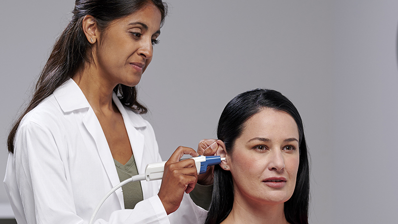 Clinician performing immittance testing with Madsen Zodiac tympanometer and Gen 2 probe on adult patient.