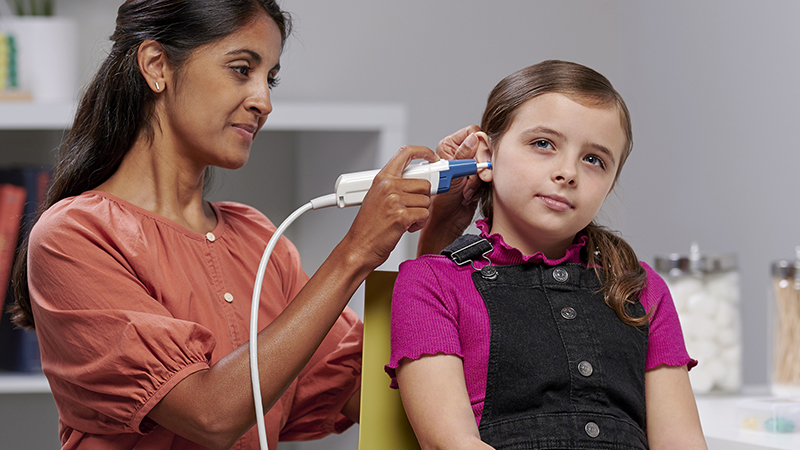 Clinician using Madsen Zodiac tympanometer for pediatric tympanometry on young girl.